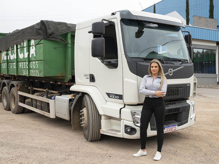 Naira diretora da reiclca em parai rs com novo caminhão da frota para realização de coletas. Branco, com caça,mba verde da marca volvo