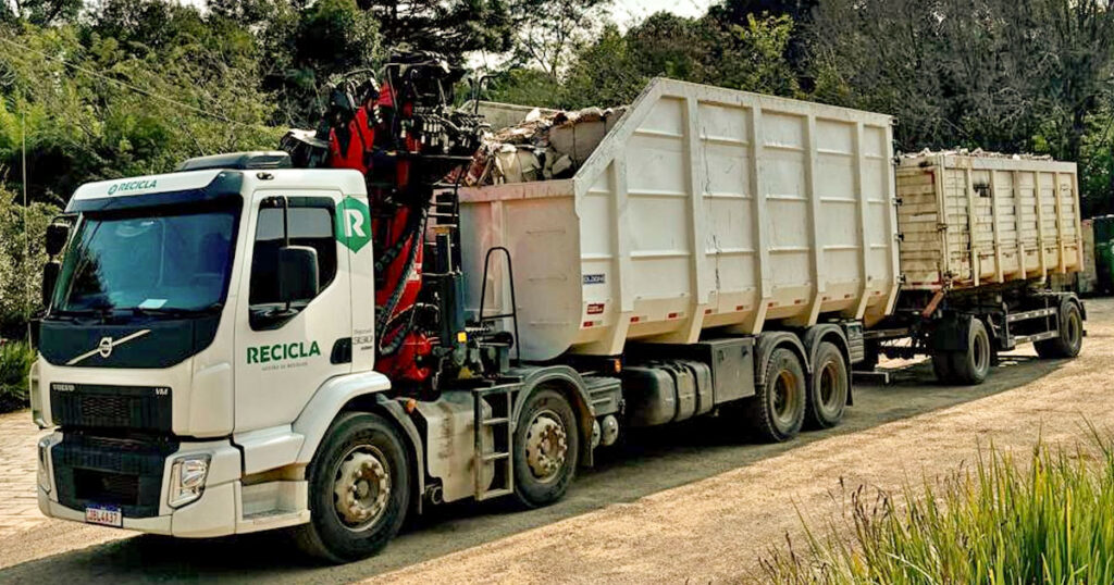 caminhão com garra sucateira de recicla, transportante sucata para gestão na serra gaucha