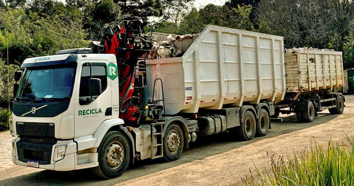 caminha camçamba branco da recicla com garra sucateira acompalda transporta sucata para reciclagem. Caminhão está parado no pátio da empresa em parai rs